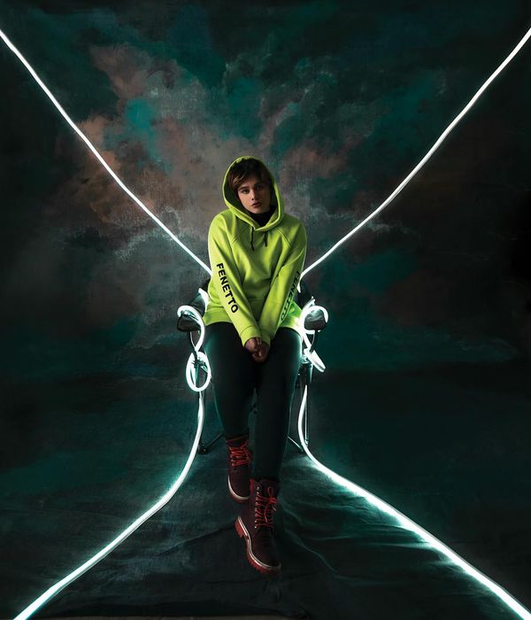 Woman in a dynamic and energetic pose against a dark background with lime green light trails.